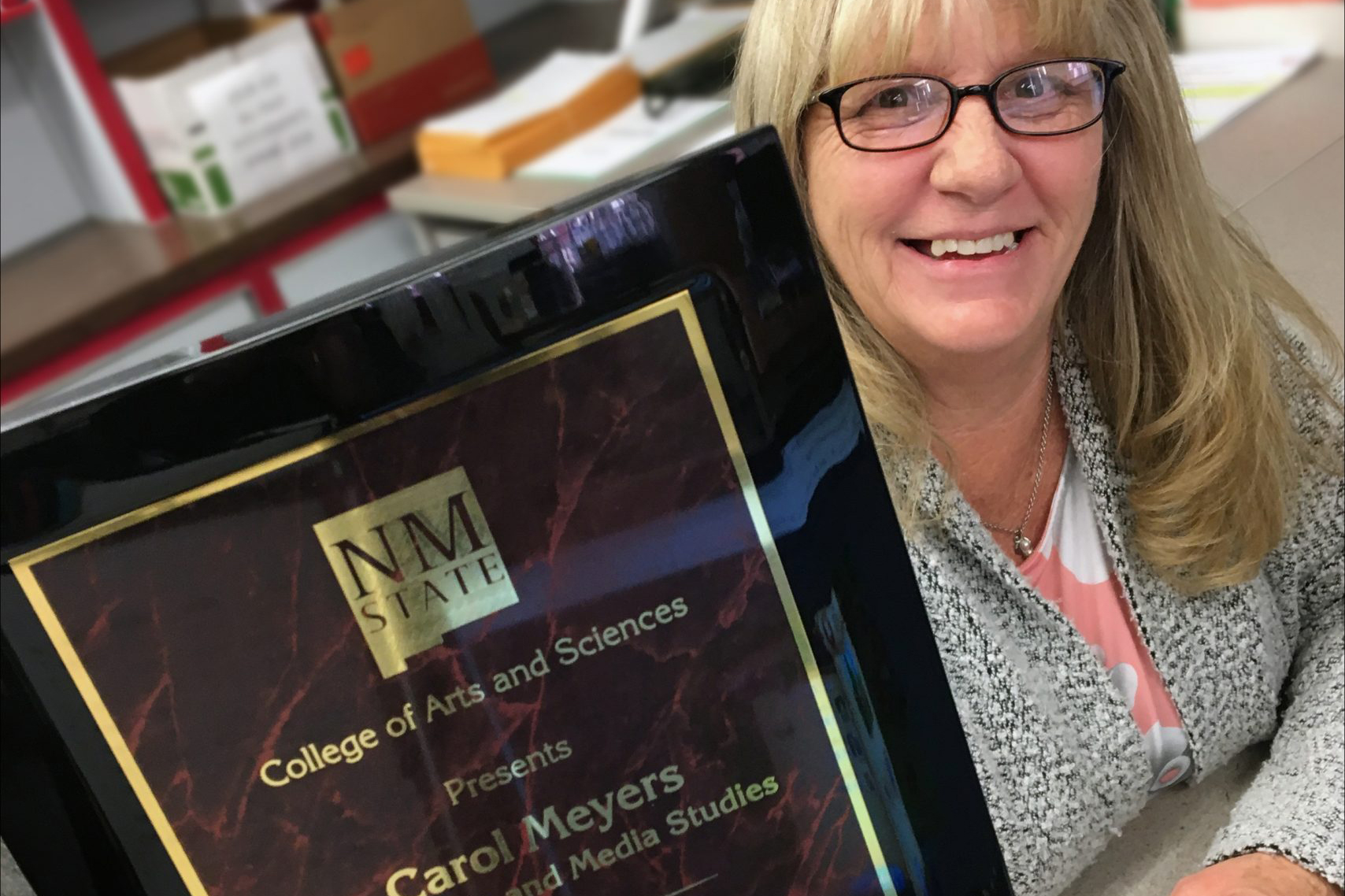 Carol Meyers holds up her award plaque